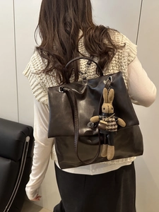 Chic black leather backpack with cute rabbit charm shown on a person for daily style