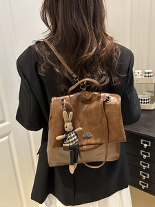 Brown leather multi-purpose backpack with a cute bunny charm and metal twist lock