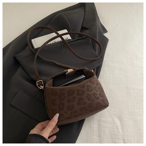 Detailansicht der Handtasche mit Leopardenmuster auf einem Blazer mit feiner Wildlederstruktur