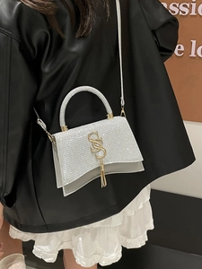 Silver sequin shoulder bag with golden S-letter buckle and tassels on leather jacket