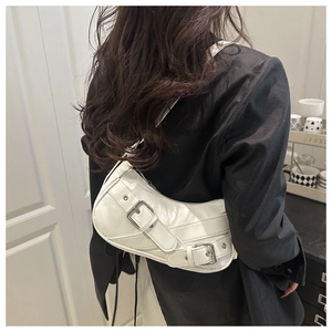 Detail of white leather crescent bag with silver buckles and moto-style belt straps