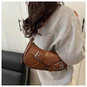 Detail view of retro brown crescent leather shoulder bag with silver decorative buckles