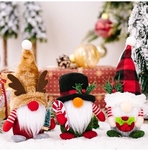 Detailed close-up of three handmade Christmas gnomes with plaid hats and deer antlers