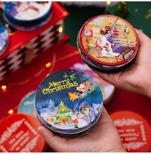 Close-up of a festive Merry Christmas tin box held by hands in a warm holiday setting