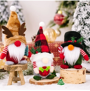 Detailed view of Christmas gnomes with plaid hats and antlers on wooden bases in snow