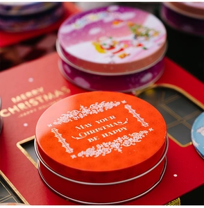 Macro detail of red tin Christmas gift box with festive engraving and glossy finish
