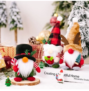 Close-up of three festive Christmas gnomes in a snowy indoor holiday setting with gifts