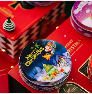 Detailed view of round Christmas tin box featuring Santa Claus and reindeer print