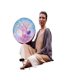 Handheld shaman drum with colorful tree of life painting and black mallet on white background