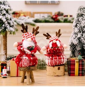 Close-up of festive Christmas reindeer gnomes on red plaid bases with warm decor