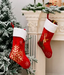 Detail of red velvet Christmas stockings with golden sequin snowflake and reindeer patterns