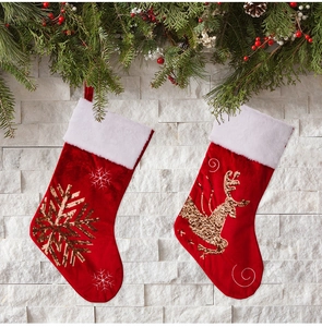 Detail of red Christmas stockings with gold sequin snowflake and reindeer patterns