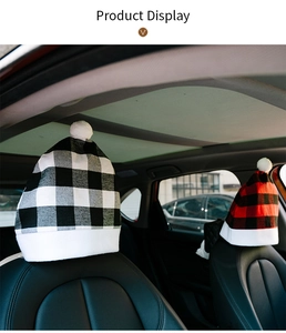 Detail of Christmas car headrest covers in red and black plaid with white pom poms