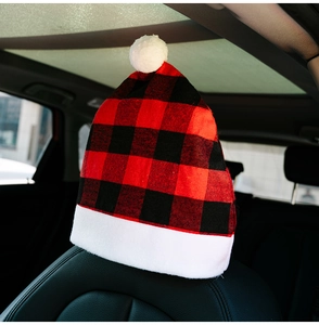 Macro detail of Christmas red black plaid car headrest cover with white plush pom-pom