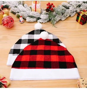 Close-up of red and white plaid Christmas hats with plush faux fur trim and pom-poms