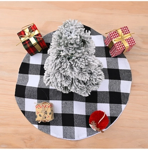 Black and white buffalo plaid Christmas tree skirt on a light wooden background
