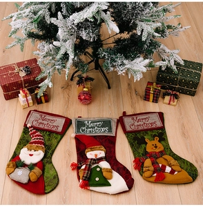 Three-piece Christmas stocking set with Santa, Snowman and Reindeer on wood background