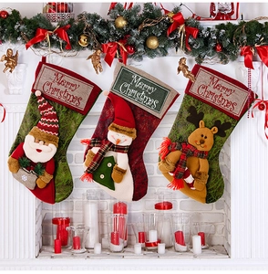 Detailed view of burlap Christmas stockings with Santa and Snowman hanging on a fireplace