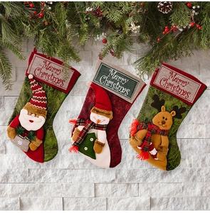 Close-up of Christmas stockings with Santa, snowman and reindeer hanging on stone wall