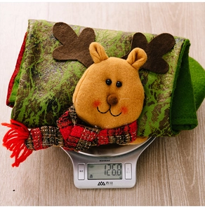 Detail of Christmas stocking featuring a plush reindeer with 126.8g weight on a scale