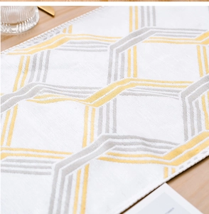 Detail of yellow and gray geometric honeycomb table runner on a wooden dining table
