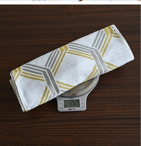 Detail shot of grey and yellow geometric table runner on a scale weighing 252.5g