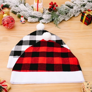 Christmas red and black buffalo plaid chair covers with white pompoms on wooden table