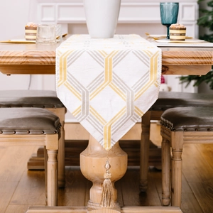 Modern white table runner with gold and grey geometric diamond patterns and tassels