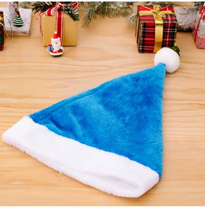 Nahaufnahme einer blauen Plüsch-Weihnachtsmütze auf einem festlichen Holztisch