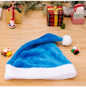 Detailaufnahme der blauen Plüsch-Weihnachtsmütze mit weißem Rand vor Festtagsdeko
