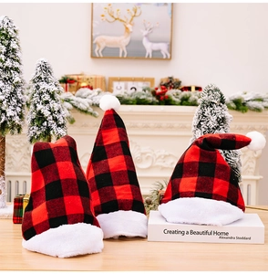Close-up of red and black buffalo plaid Christmas hats with white plush trim and pom-poms