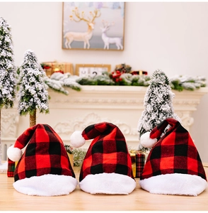 Three red and black buffalo plaid Christmas hats with white faux fur trim on a wood surface