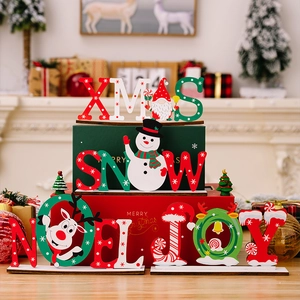 Dettaglio delle decorazioni natalizie in legno XMAS SNOW NOEL JOY con figure di festa