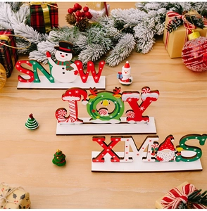 Dettaglio dei cartelli natalizi in legno SNOW, JOY e XMAS con decorazioni festive