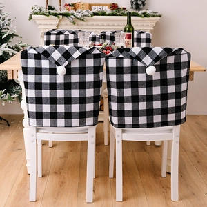 Détail de housse de chaise de Noël à carreaux noirs et blancs avec pompon blanc festif
