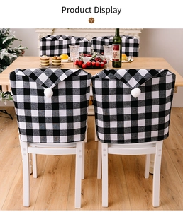 Détail de housses de chaise de Noël à carreaux noirs et blancs avec pompons festifs