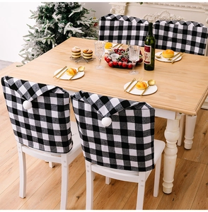 Vue détaillée des housses de chaise de Noël à carreaux noirs et blancs avec pompons
