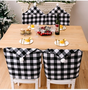 Détail de housses de chaise chapeau de Noël à carreaux noirs et blancs avec pompons