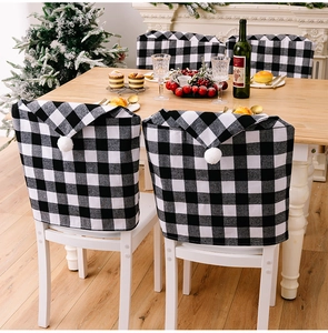 Détail de housses de chaise de Noël à carreaux noirs et blancs avec pompons doux