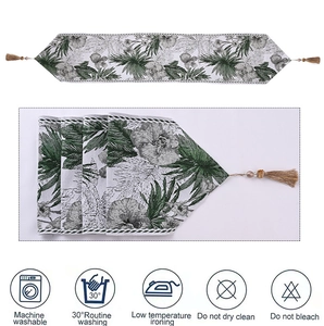 Detail of table runner with green floral ink patterns and brown fringe tassels decoration