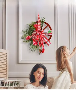 Detail of Christmas wreath with red wheel, elf hat, and Merry Christmas sign on a wall