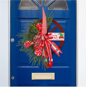 Detail of Christmas wheel wreath with elf legs and Merry Christmas sign on blue door