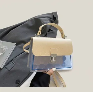 Détail du rabat en cuir beige et du sac bandoulière en PVC bleu transparent