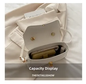 Detailed interior of a white flap crossbody bag showing storage for phone and makeup