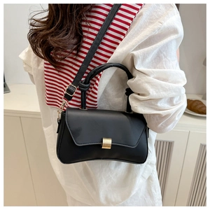 Detail showing adjustable shoulder strap with golden metal buckle on black crossbody bag