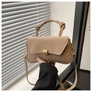 Detail view of the beige PU leather handbag showing knot handle and gold metal buckle