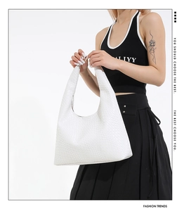 Detailed close-up of a white Hobo bag featuring premium woven texture and wide shoulder strap