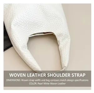 Detail of a wide comfortable shoulder strap on a white woven tote bag with PU texture