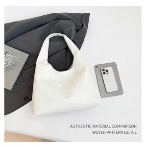 Detail shot of white woven texture on a large hobo tote bag with a minimalist design