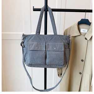 Detailansicht der grauen Cord-Einkaufstasche mit zwei Cargotaschen und Metallschnallen